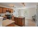 Kitchen with island, wooden cabinets, stainless appliances, and adjacent dining area at 8238 Crackling Ln, Indianapolis, IN 46259
