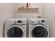 Bright laundry area features a modern washer, dryer and open shelving for storage at 8238 Crackling Ln, Indianapolis, IN 46259