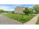 Well-maintained side yard with lush green grass, sidewalk, and partial water view at 8238 Crackling Ln, Indianapolis, IN 46259