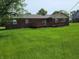 Green backyard view of brick house with a deck perfect for outdoor entertaining at 8510 E Mcgregor Rd, Indianapolis, IN 46259