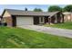 Brick ranch-style house featuring an attached two-car garage and a spacious driveway at 8510 E Mcgregor Rd, Indianapolis, IN 46259