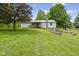 Spacious backyard with a deck, lush lawn, mature trees and tiered retaining wall at 8513 S 575 W, Morgantown, IN 46160