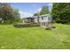 Spacious backyard view of the home with a covered porch, brick-paved retaining wall, and landscaped lawn at 8513 S 575 W, Morgantown, IN 46160