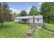 Exterior rear view featuring a covered porch and terraced backyard with stone accents at 8513 S 575 W, Morgantown, IN 46160