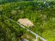 Aerial view of a wooded lot with cleared space for development and a road nearby at 9602 Fall Creek Rd, Indianapolis, IN 46256