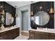 Modern bathroom featuring double vanities, marble wall tiles, and stylish bronze pendant lighting at 9602 Fall Creek Rd, Indianapolis, IN 46256