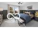 Cozy bedroom with wainscoting detail, a plush bed, and a large window overlooking the greenery creating a tranquil retreat at 9602 Fall Creek Rd, Indianapolis, IN 46256
