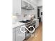 Modern kitchen with white cabinets, stainless steel appliances, and a herringbone backsplash at 9602 Fall Creek Rd, Indianapolis, IN 46256