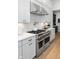 Gourmet kitchen featuring stainless steel range hood, herringbone backsplash, and ample counter space at 9602 Fall Creek Rd, Indianapolis, IN 46256