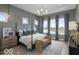 Serene primary bedroom with tray ceiling, calming colors, large windows, and elegant furnishings at 9602 Fall Creek Rd, Indianapolis, IN 46256