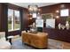 Sophisticated office with custom wood desk, built-in shelving, and natural light from the window at 9602 Fall Creek Rd, Indianapolis, IN 46256