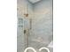 A luxury marble-tiled shower featuring bronze fixtures, glass enclosure, and built in niche at 9602 Fall Creek Rd, Indianapolis, IN 46256