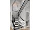 A modern staircase with dark wood railings and white walls, leading to the upper level at 9602 Fall Creek Rd, Indianapolis, IN 46256