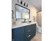 Modern bathroom featuring a navy blue vanity with gold hardware, a black framed mirror and a shower at 9655 Cedar Cove Ln, Indianapolis, IN 46250