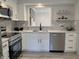 Well-lit kitchen featuring stainless steel appliances, white cabinetry, and elegant countertops at 9655 Cedar Cove Ln, Indianapolis, IN 46250