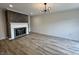 Spacious living room with modern light fixture, wood floors and a fireplace with a dark gray accent wall at 9655 Cedar Cove Ln, Indianapolis, IN 46250