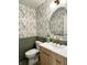 Stylish powder room with floral wallpaper, green wainscoting and a vanity with a gold faucet at 9655 Cedar Cove Ln, Indianapolis, IN 46250