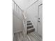 Bright staircase with carpeted steps, white railing, and wood floors at the base at 9655 Cedar Cove Ln, Indianapolis, IN 46250