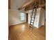 Finished attic with hardwood floors, a loft ladder, and natural light at 989 Woodruff Pl E Dr, Indianapolis, IN 46201
