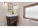 Stylish bathroom featuring a modern wood vanity, unique mirror, and a textured glass window for natural light at 989 Woodruff Pl E Dr, Indianapolis, IN 46201