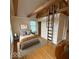 Cozy bedroom with exposed beams, hardwood floors, and ladder to an overhead loft area at 989 Woodruff Pl E Dr, Indianapolis, IN 46201