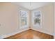 Bedroom featuring hardwood flooring and two light-filled windows at 989 Woodruff Pl E Dr, Indianapolis, IN 46201
