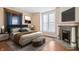Comfortable bedroom featuring a cozy fireplace, hardwood floors, and lots of natural light at 989 Woodruff Pl E Dr, Indianapolis, IN 46201