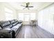 Bright living room with large windows, ceiling fan, and sliding doors leading to outdoor area at 1021 Boots Trl, Greenfield, IN 46140