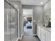 Bright bathroom featuring dual sinks, a glass-enclosed shower, and a view to the main bedroom at 1136 Tansley Ln, Avon, IN 46123