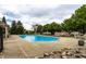 Large community swimming pool with ample deck space, surrounded by lush trees and greenery at 11646 Winding Wood Dr, Indianapolis, IN 46235