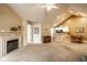 Open living room with fireplace, neutral carpeting, and breakfast bar to kitchen at 11646 Winding Wood Dr, Indianapolis, IN 46235