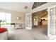 Bright living area featuring neutral tones, vaulted ceilings, and a glimpse of the kitchen through glass doors at 11646 Winding Wood Dr, Indianapolis, IN 46235
