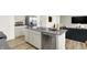 Modern kitchen island featuring stainless steel appliances and adjacent living area with panelled accent wall at 11904 Vale St, Indianapolis, IN 46235