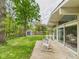 Backyard featuring mature trees, a shed, green grass, and patio with rocking chairs at 12 Windridge St, Country Club Heights, IN 46011