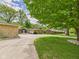 Long driveway leading to stone-clad ranch-style home with well-manicured lawn at 12 Windridge St, Country Club Heights, IN 46011