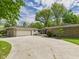 Spacious single-story home featuring a long driveway, stone accents, and an attached two-car garage at 12 Windridge St, Country Club Heights, IN 46011