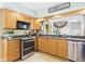 Inviting kitchen with stainless appliances, decorative window, granite counters, and ample natural light at 12 Windridge St, Country Club Heights, IN 46011