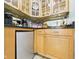 Compact kitchen features light wood cabinets, sleek countertops, and mirrored backsplash to enhance light and space at 12 Windridge St, Country Club Heights, IN 46011