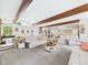 Expansive living room with exposed beams, multiple seating areas, and ample natural light is perfect for relaxing at 12 Windridge St, Country Club Heights, IN 46011