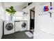 Bright laundry room featuring washer, dryer, storage, and a charming plant for added freshness at 1207 Chestnut St, Columbus, IN 47201