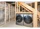Laundry room in unfinished basement with exposed brick and framing, includes washer and dryer at 1212 S Senate Ave, Indianapolis, IN 46225