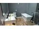 Modern bathroom featuring a soaking tub, unique fixtures, and tiled accent wall at 1212 S Senate Ave, Indianapolis, IN 46225