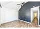 Bedroom features wood flooring, vaulted ceiling, and dark accent wall, offering modern design at 1212 S Senate Ave, Indianapolis, IN 46225