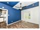 This is a bedroom with wood floors, a ceiling fan, and a blue accent wall at 1212 S Senate Ave, Indianapolis, IN 46225