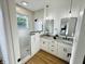 Bright bathroom featuring dual vanities, stone countertops, modern fixtures, and a walk-in shower with glass door at 1231 Marlowe Ave, Indianapolis, IN 46202