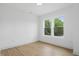This empty bedroom has neutral walls, light wood floors, and bright windows at 1231 Marlowe Ave, Indianapolis, IN 46202