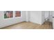 Bright bedroom featuring wood-look flooring, white walls, and a window with a view of neighboring homes at 1231 Marlowe Ave, Indianapolis, IN 46202