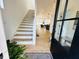 Inviting entryway features an open staircase, flowing into a bright living space with hardwood floors and stylish black accents at 1231 Marlowe Ave, Indianapolis, IN 46202