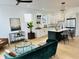 Open-concept living room with a stylish green sofa, a modern kitchen with stainless steel appliances, and bright lighting at 1231 Marlowe Ave, Indianapolis, IN 46202