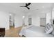 Bright main bedroom featuring light hardwood flooring, ceiling fan, ensuite and walk-in closets at 1231 Marlowe Ave, Indianapolis, IN 46202